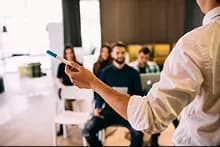 Personne de dos donnant une formation à des personnes