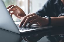 Mains tapant sur un clavier d'ordinateur